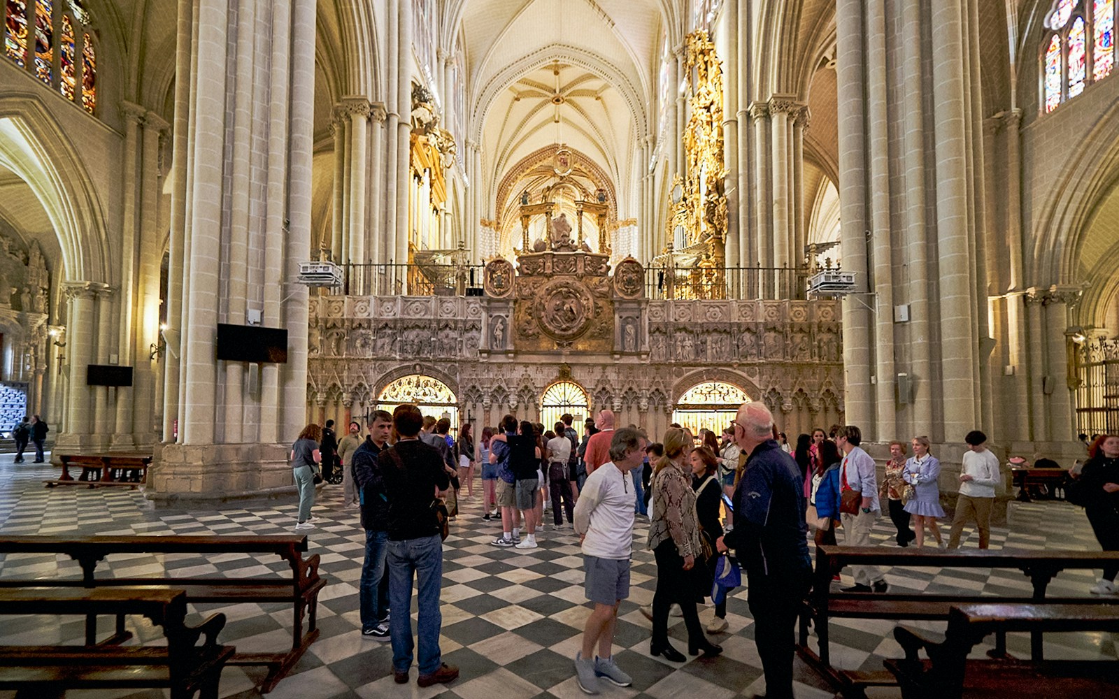 Visitors exploring the ornate interior of Toledo Cathedral, Spain.