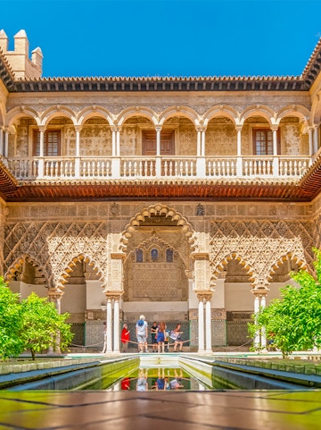 Courtyard with intricate arches and reflecting pool at Alcazar of Seville.