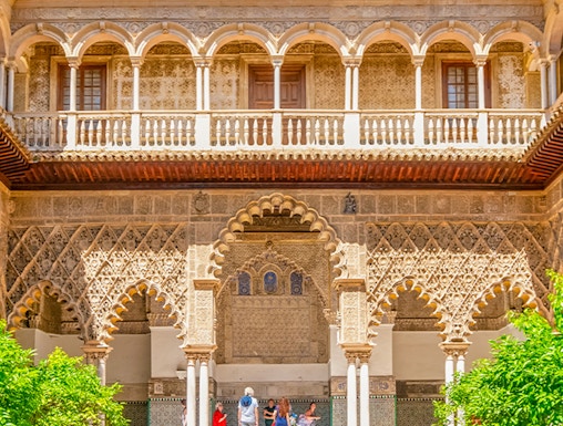 Courtyard with intricate arches and reflecting pool at Alcazar of Seville.