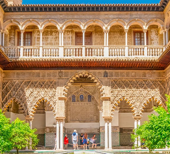 Courtyard with intricate arches and reflecting pool at Alcazar of Seville.
