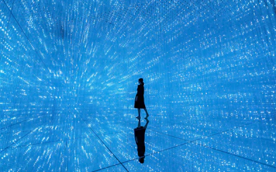 Silhouette in blue digital art installation at TeamLab Planets Tokyo.