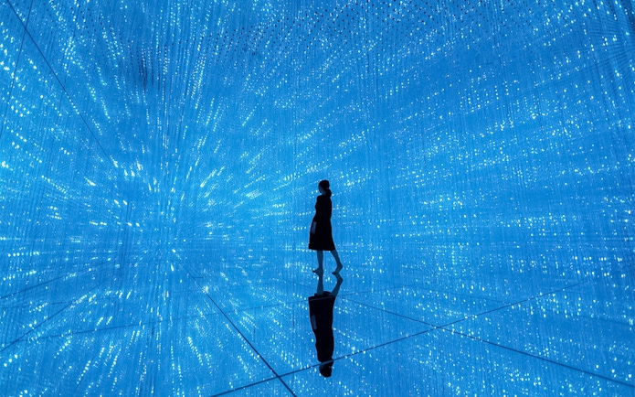 Silhouette in blue digital art installation at TeamLab Planets Tokyo.