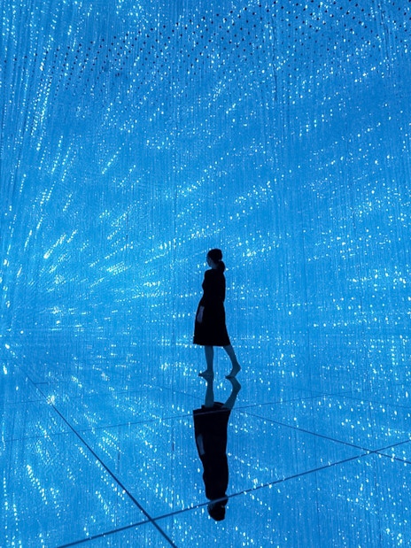 Silhouette in blue digital art installation at TeamLab Planets Tokyo.