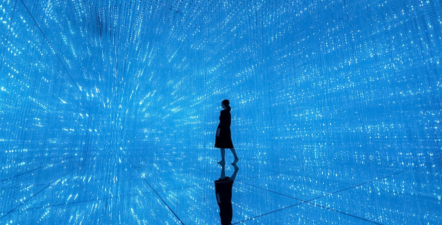 Silhouette in blue digital art installation at TeamLab Planets Tokyo.
