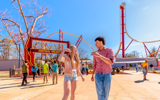 Visitors walking near THE FLASH™ Vertical Velocity ride at Six Flags Great Adventure.