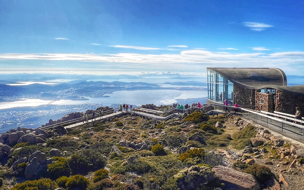 Visitors walking on the boardwalk at Mt Wellington summit, overlooking Hobart, Tasmania.