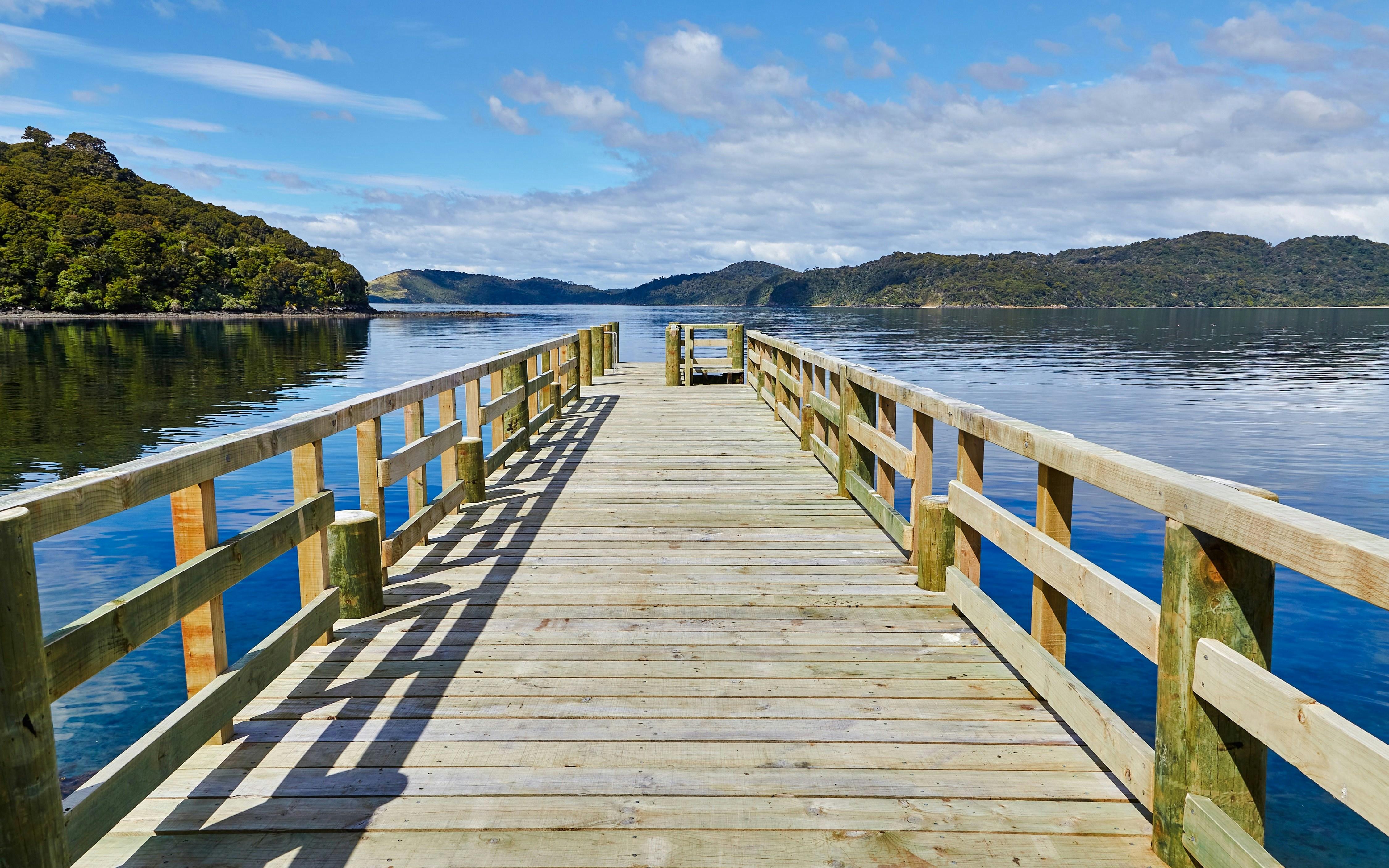 Wooden pier extending into the water at Port William, Stewart Island.