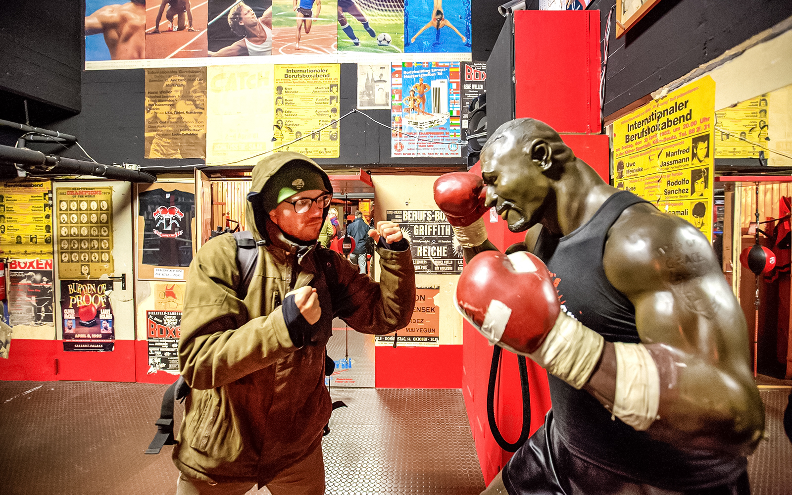 Man posing with boxing statue in St. Pauli museum during Sex & Crime Tour.