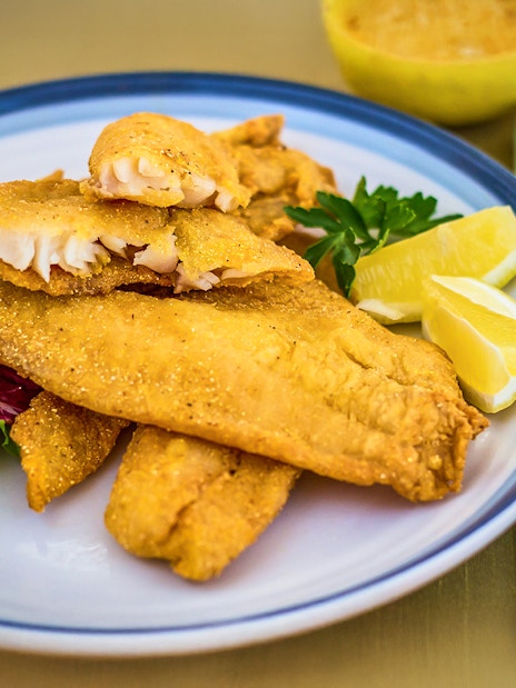 Breaded catfish with lemon wedges on Steamboat Natchez lunch cruise plate.