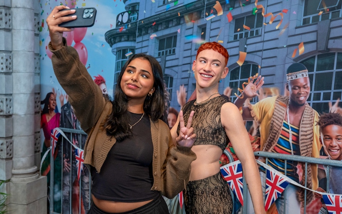 Visitors taking a selfie with wax figures at Madame Tussauds London.