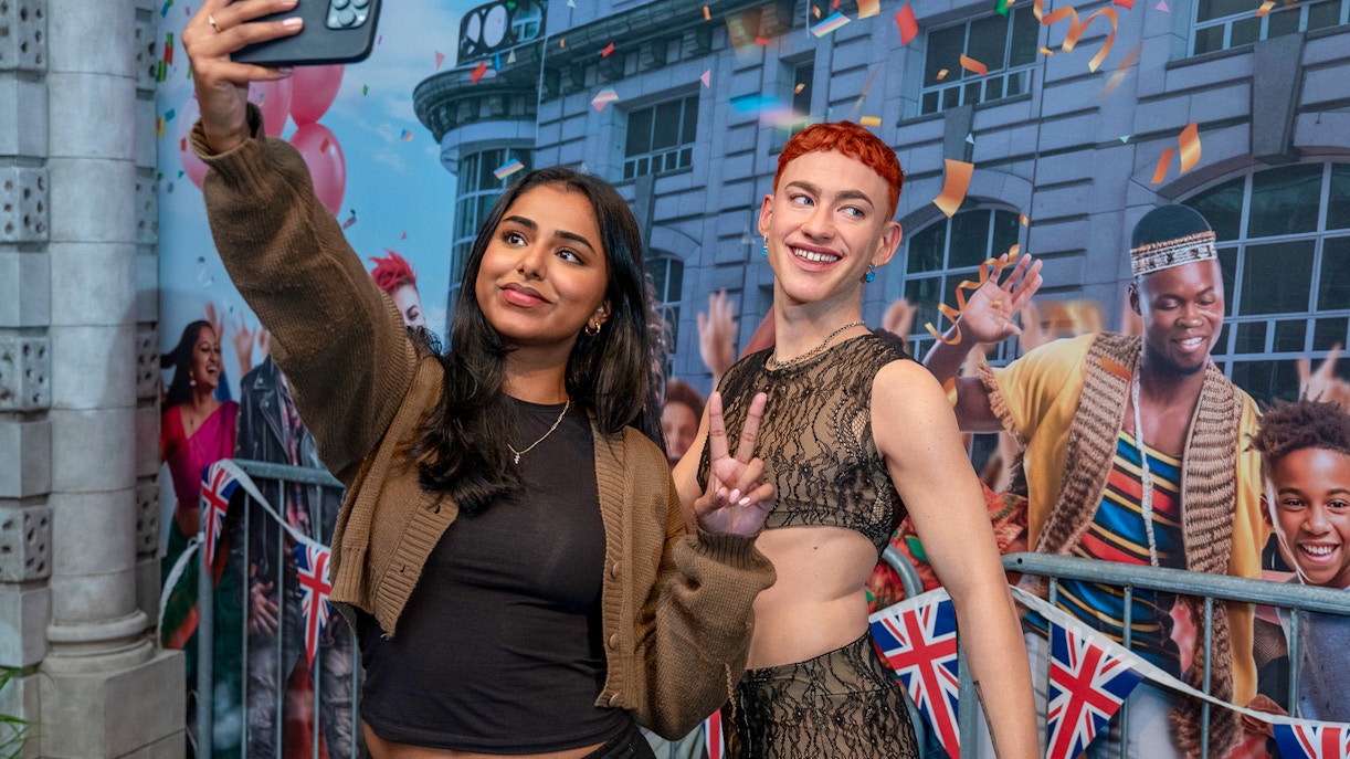 A woman clicking selfie with Olly Alexander