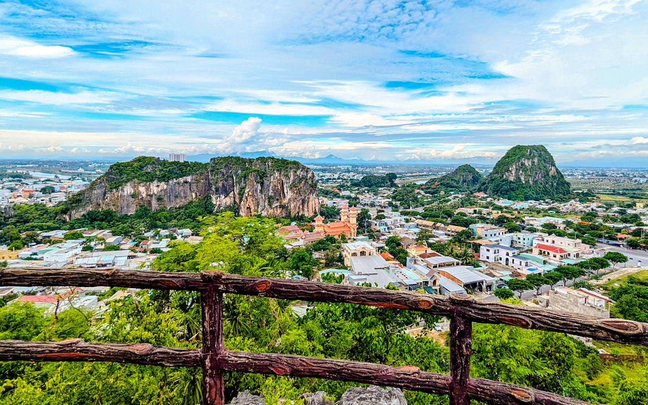 Marble Mountains view over Da Nang cityscape with lush greenery and rocky peaks.