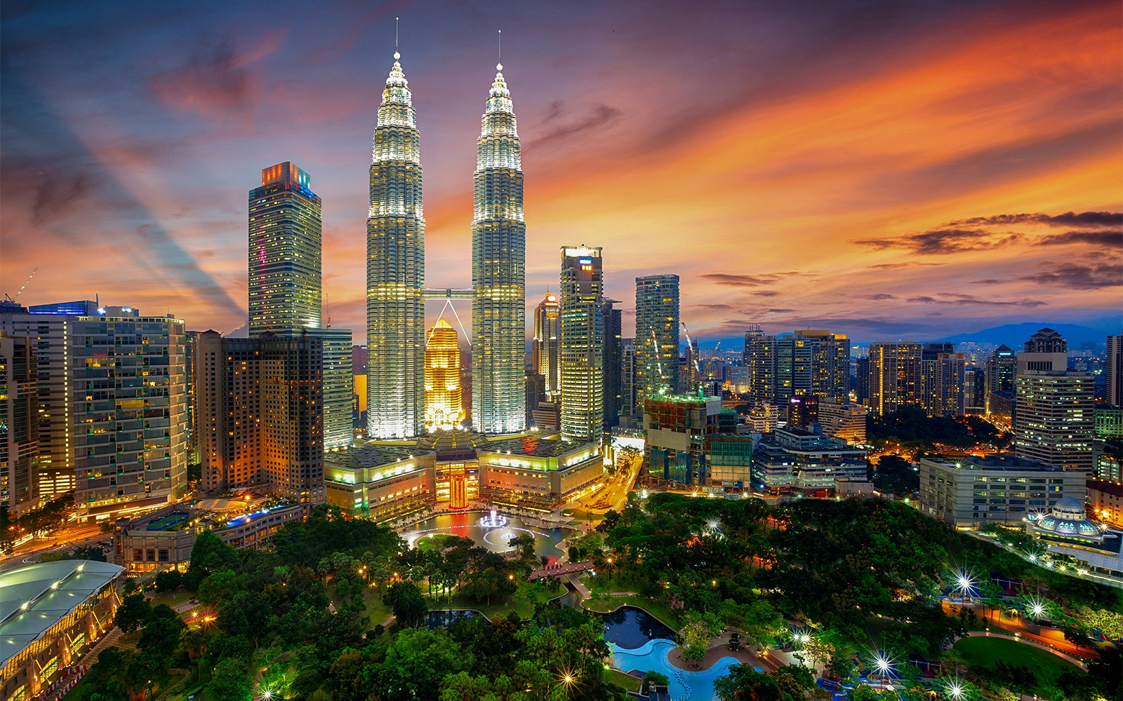 Petronas Twin Towers illuminated at sunset in Kuala Lumpur, Malaysia.