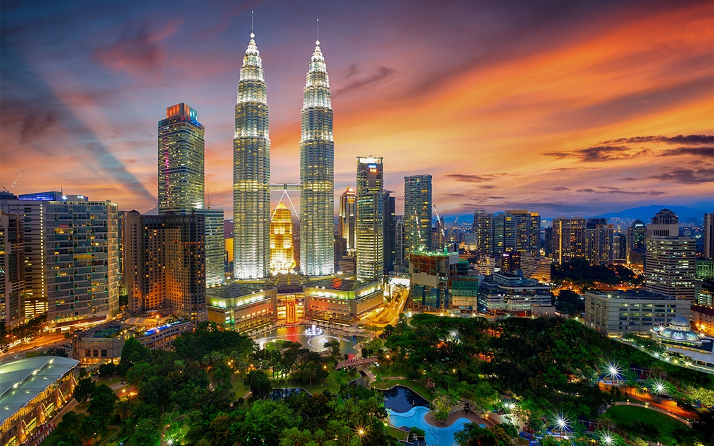 Petronas Twin Towers illuminated at sunset in Kuala Lumpur, Malaysia.