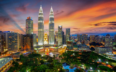 Petronas Twin Towers illuminated at sunset in Kuala Lumpur, Malaysia.