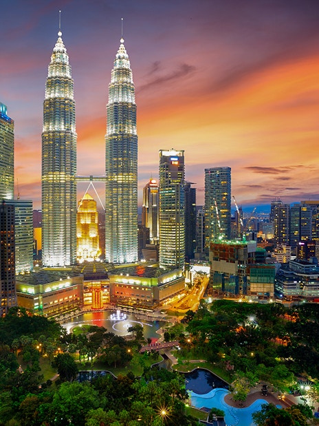 Petronas Twin Towers illuminated at sunset in Kuala Lumpur, Malaysia.