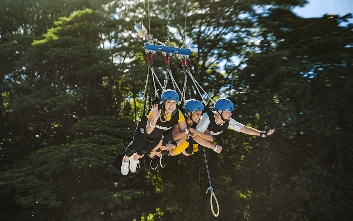 Friends swinging on a giant swing at Skypark Sentosa by AJ Hackett, Singapore.