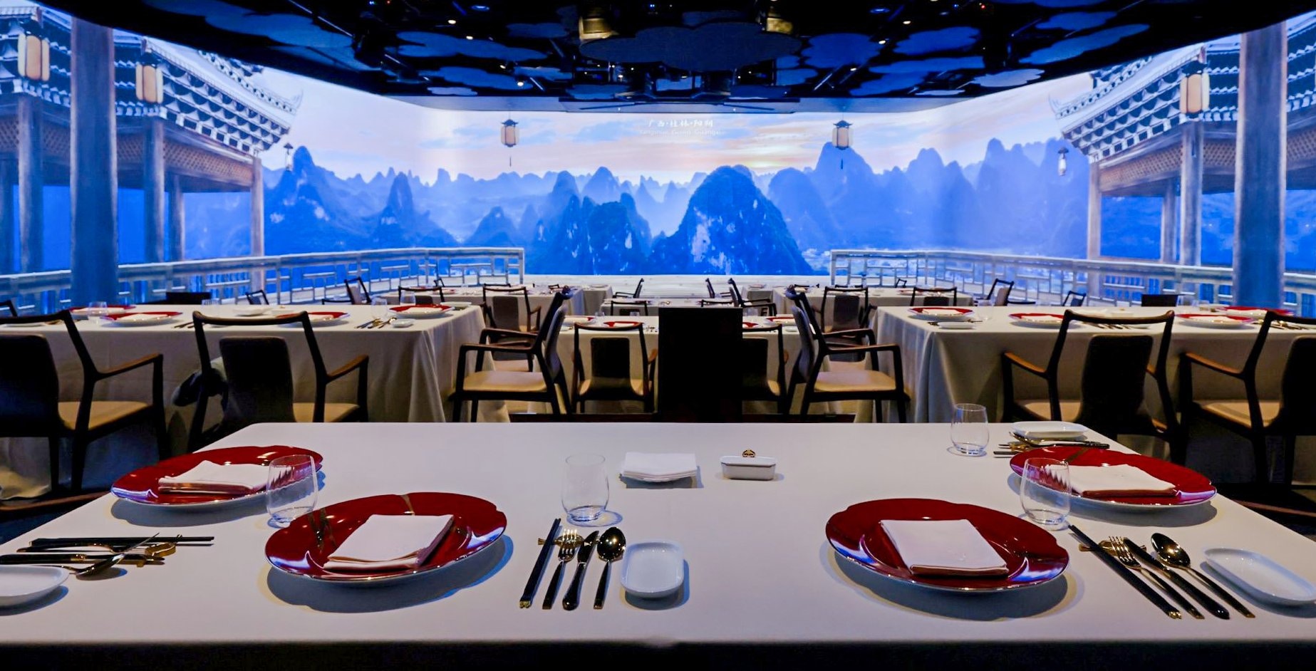 Elegant dining setup at TASTE OF CHINA with mountain view backdrop.