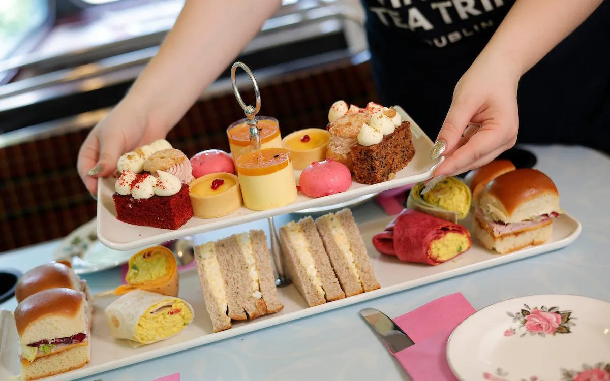 Assorted pastries and sandwiches served on a tiered tray during a vintage tea tour.