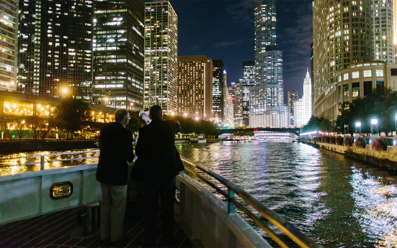 Cruise on Chicago River with city skyline at night.