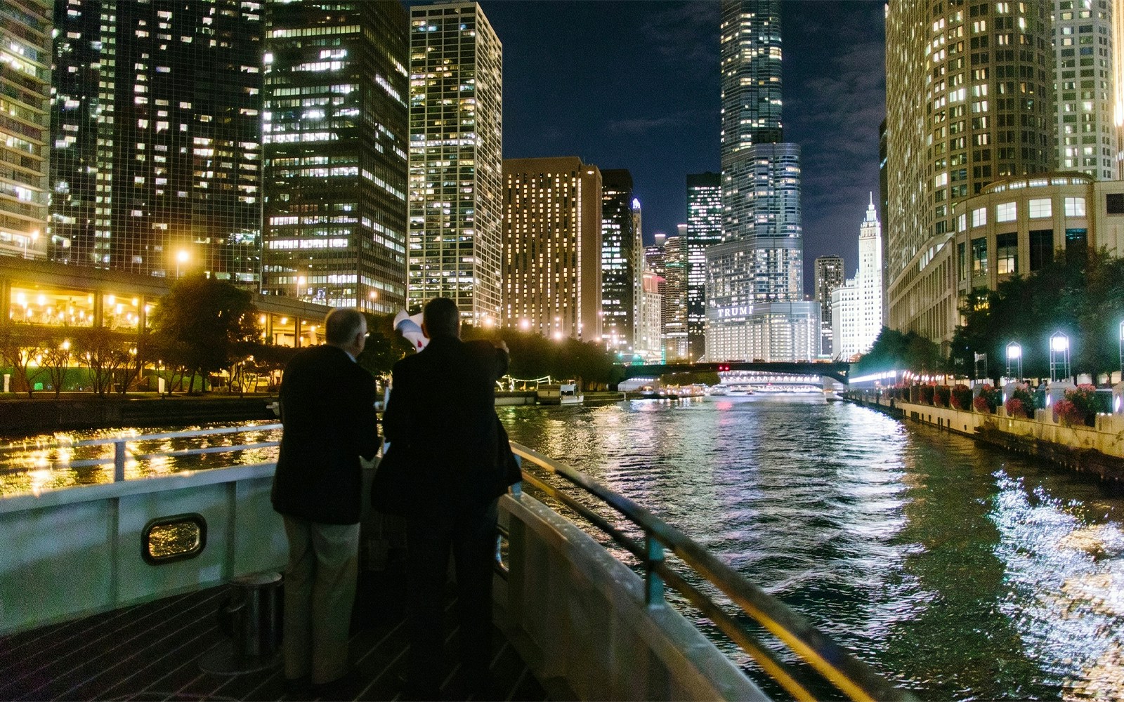 Cruise on Chicago River with city skyline at night.