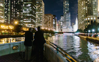 Cruise on Chicago River with city skyline at night.