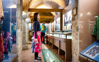 Female guest viewing exhibits inside Meteora Monastery, Greece.