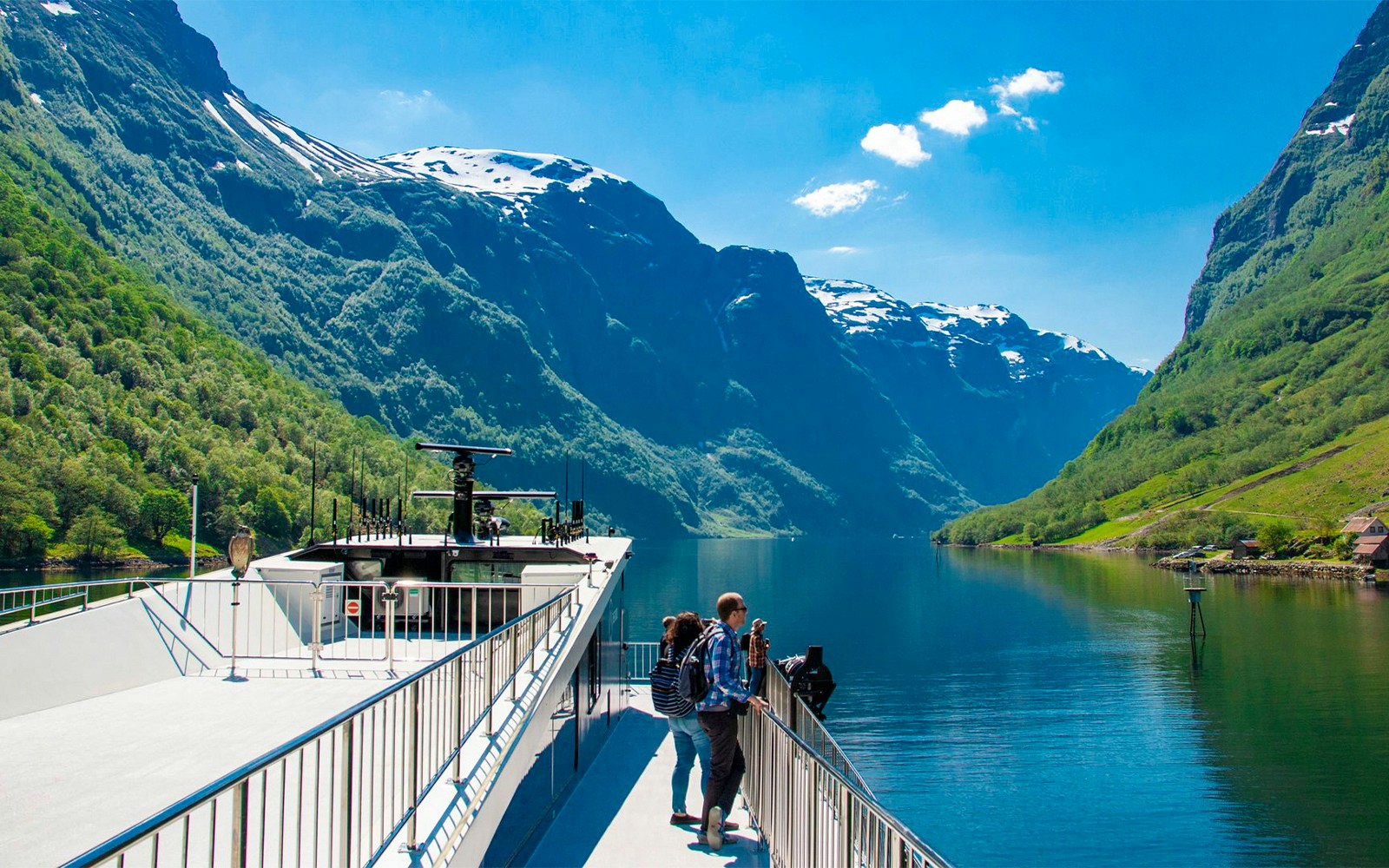 Cruise ship on Nærøyfjord with passengers enjoying scenic mountain views, Norway.