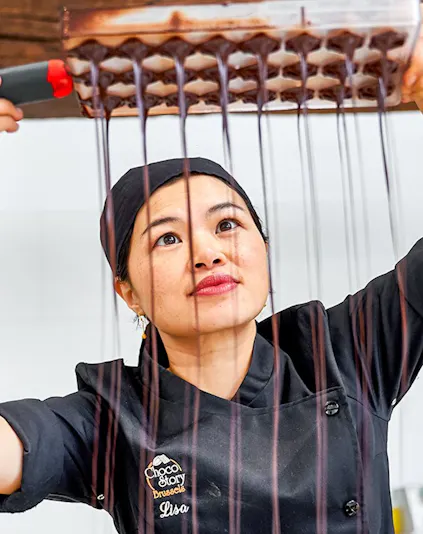 Chocolatier pouring chocolate into molds at Choco Story Brussels.