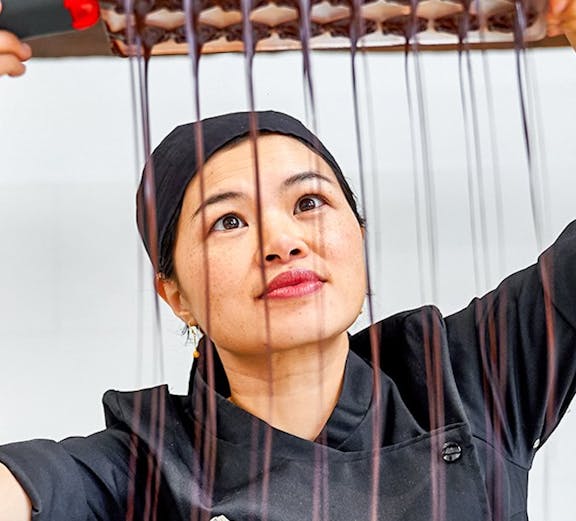 Chocolatier pouring chocolate into molds at Choco Story Brussels.