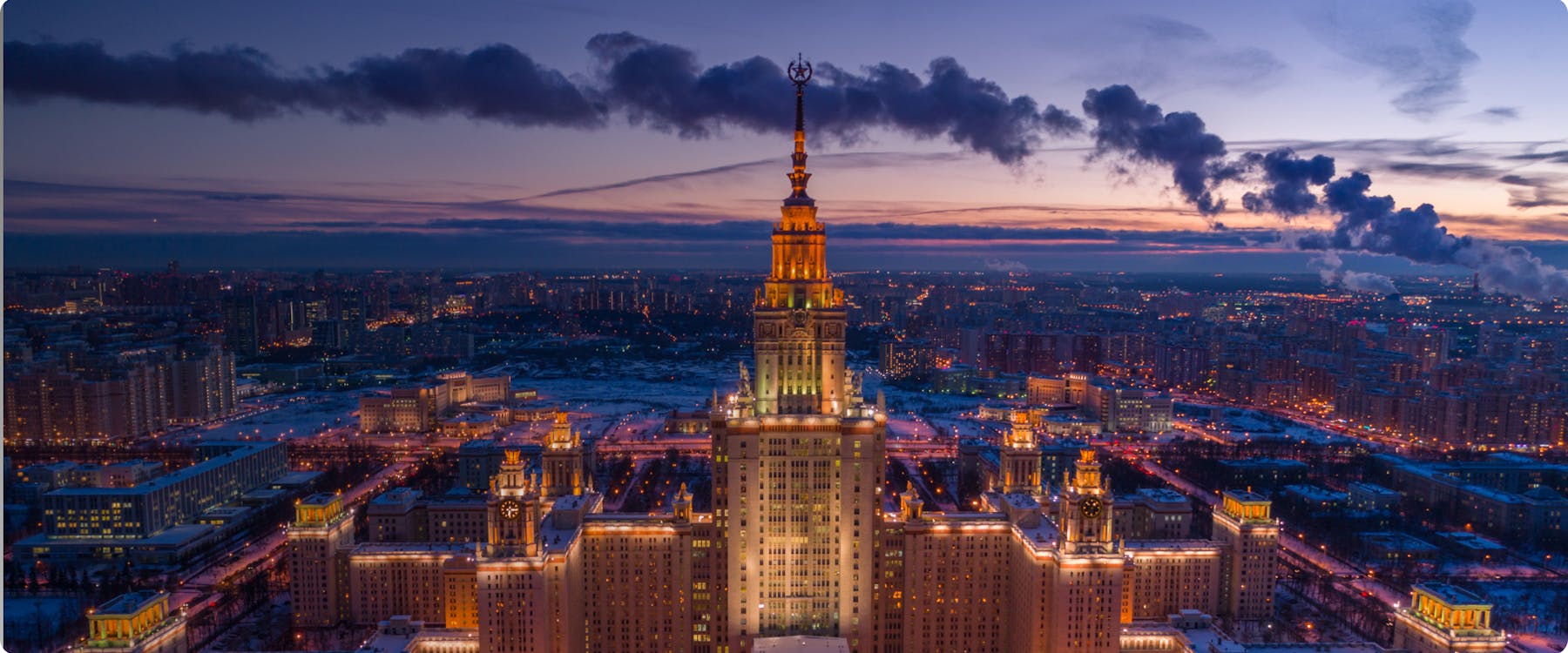 Moscow State University at dusk with city skyline.