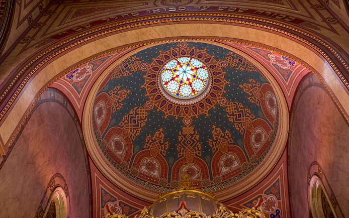 Stained glass dome interior of the Great Synagogue, intricate patterns and vibrant colors.
