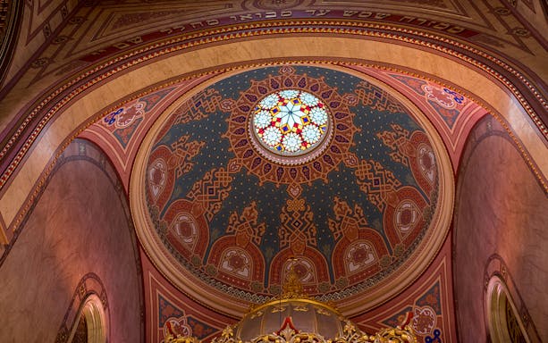 Stained glass dome interior of the Great Synagogue, intricate patterns and vibrant colors.