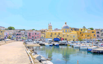Colorful buildings and boats at the harbor of Procida Island, Italy.