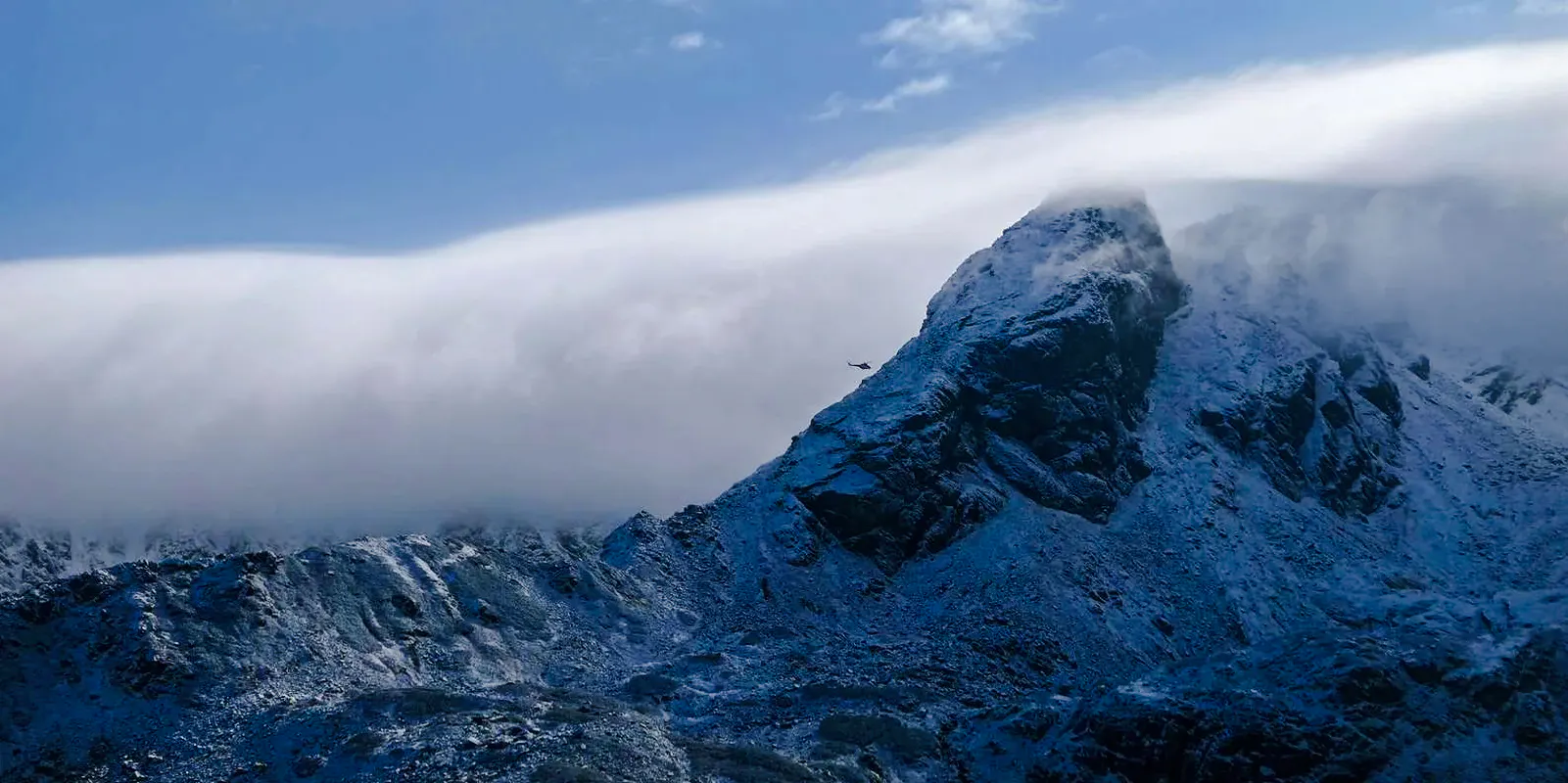 Helicopter flying near snow-covered peaks in the Everest Region, Nepal.