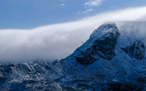 Helicopter flying near snow-covered peaks in the Everest Region, Nepal.
