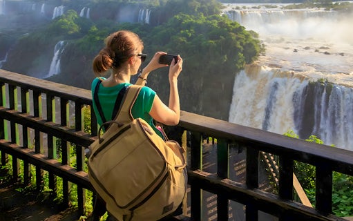 Tourist taking photo at Iguazú Falls viewing platform, Brazilian side.