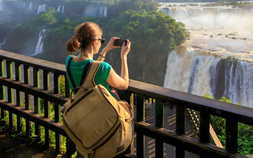 Tourist taking photo at Iguazú Falls viewing platform, Brazilian side.