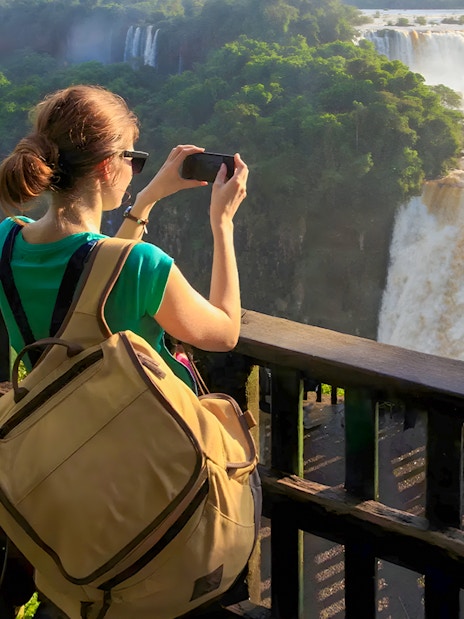 Tourist taking photo at Iguazú Falls viewing platform, Brazilian side.