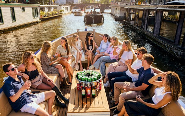 Guests enjoying drinks on a canal cruise in Amsterdam.
