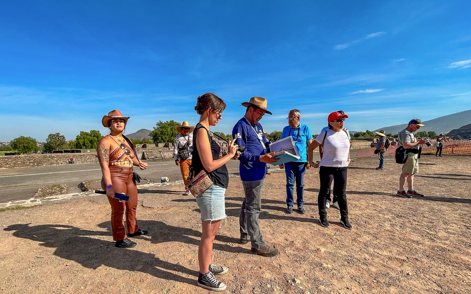 Tour group exploring Teotihuacan, Mexico with a guide explaining the site.