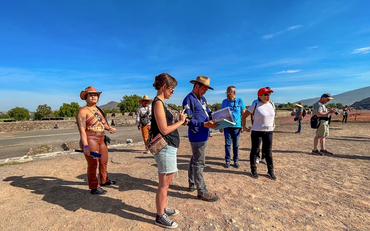 Tour group exploring Teotihuacan, Mexico with a guide explaining the site.