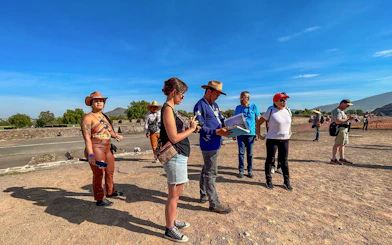 Tour group exploring Teotihuacan, Mexico with a guide explaining the site.