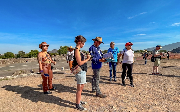 Tour group exploring Teotihuacan, Mexico with a guide explaining the site.