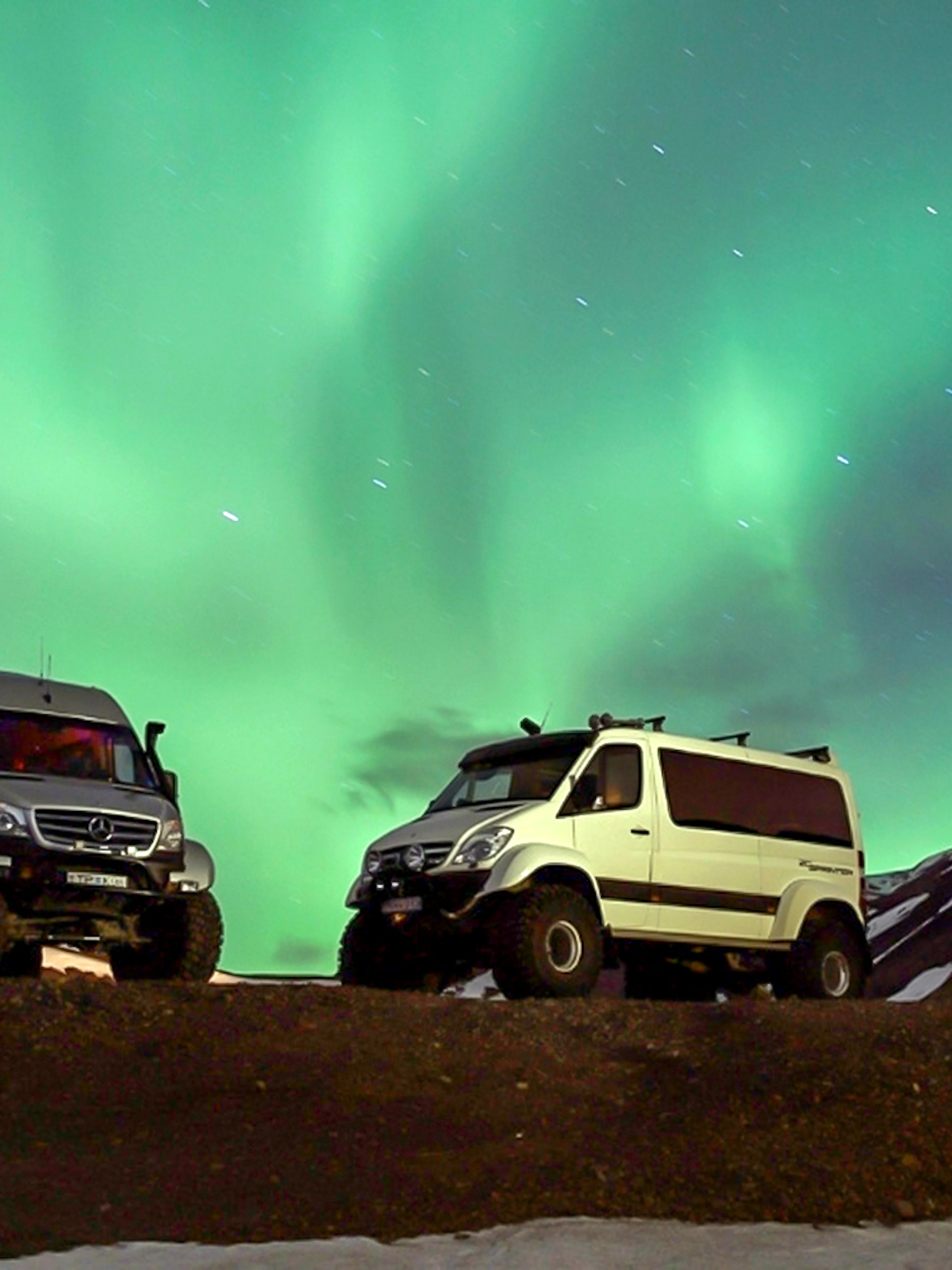 Premium jeeps under Northern Lights during Iceland tour.