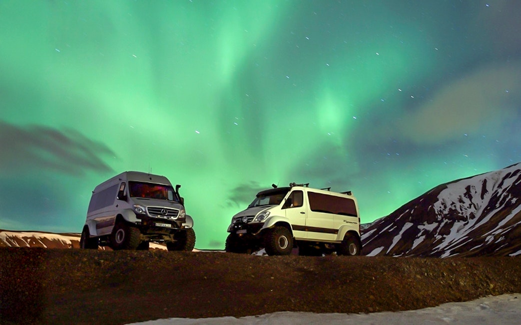 Premium jeeps under Northern Lights during Iceland tour.