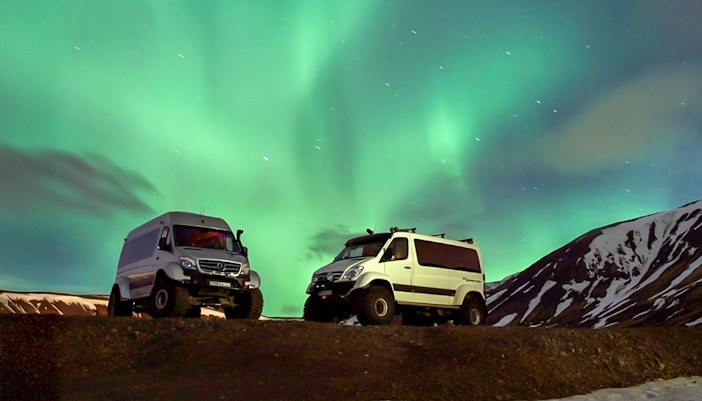 Premium jeeps under Northern Lights during Iceland tour.
