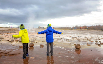 Children observing geyser eruption on Golden Circle tour, Iceland.