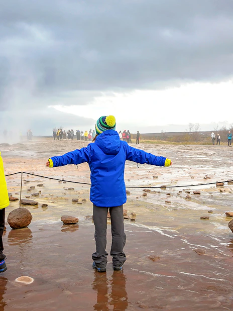 Children observing geyser eruption on Golden Circle tour, Iceland.