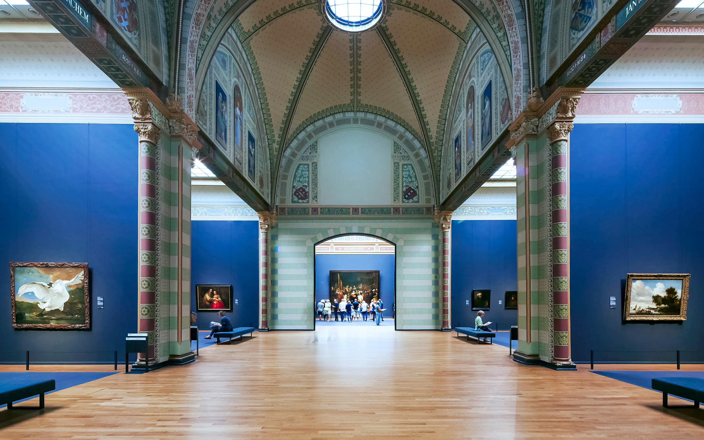 Gallery of Honor at Rijksmuseum, Amsterdam, featuring classic paintings and visitors exploring the exhibits.